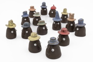 Assorted tiny stoneware containers with hats and faces