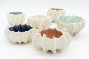 Grouping of six small porcelain vessels with various interior glaze colors